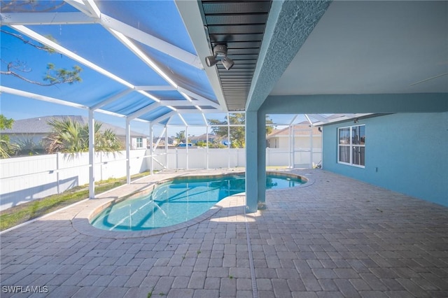 view of pool featuring glass enclosure, a patio, a fenced in pool, and a fenced backyard