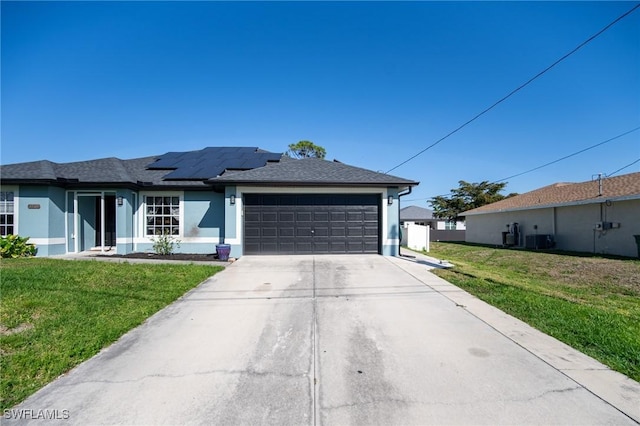 view of front of property featuring stucco siding, a front lawn, concrete driveway, an attached garage, and solar panels