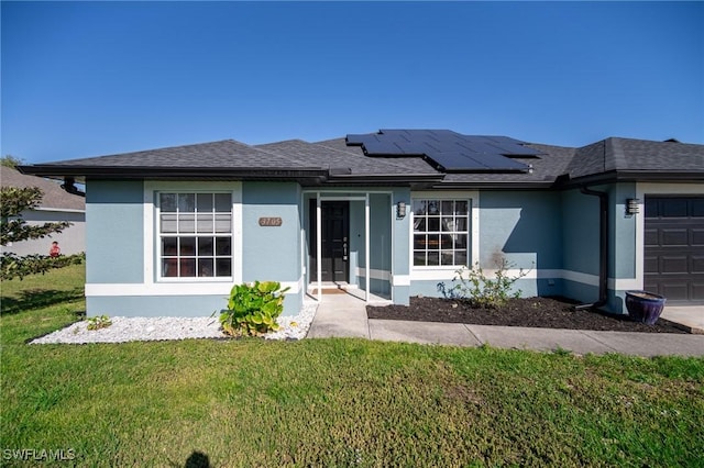 view of front of house with solar panels, a front yard, an attached garage, and stucco siding