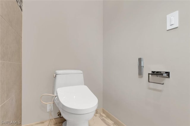 bathroom featuring baseboards, toilet, and marble finish floor