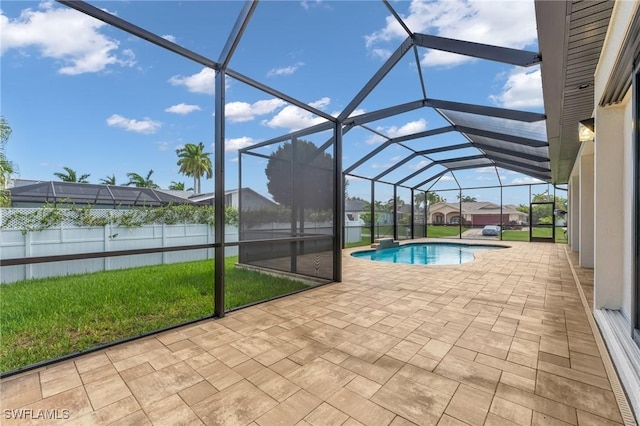 outdoor pool featuring glass enclosure and a patio