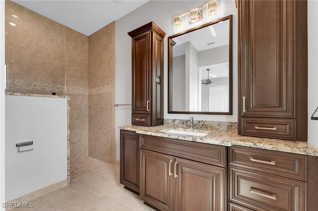 bathroom featuring tile patterned flooring, a ceiling fan, vanity, and a walk in shower