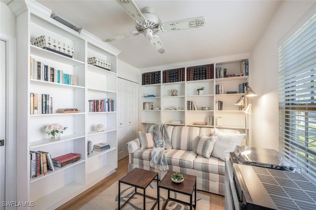 living area featuring wood finished floors, visible vents, and ceiling fan