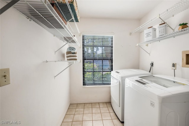 laundry room featuring light tile patterned flooring, laundry area, and washing machine and dryer