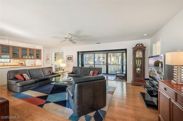 living room featuring visible vents, light wood finished floors, and ceiling fan