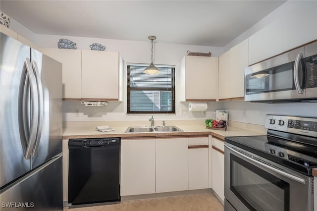 kitchen featuring pendant lighting, a sink, white cabinetry, stainless steel appliances, and light countertops