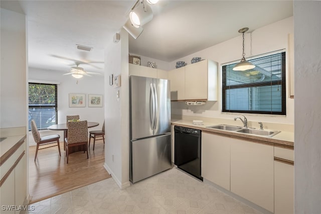 kitchen with ceiling fan, decorative light fixtures, black dishwasher, freestanding refrigerator, and a sink