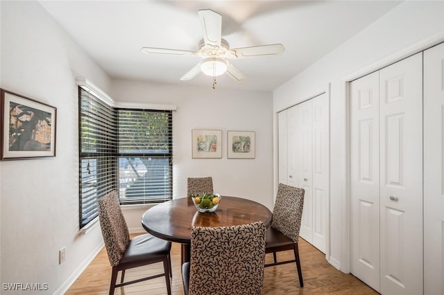 dining area with baseboards, light wood-type flooring, and ceiling fan