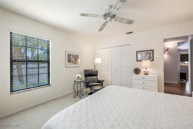 carpeted bedroom with a ceiling fan, baseboards, visible vents, and a closet