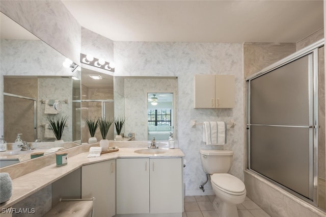 bathroom with tile patterned flooring, wallpapered walls, toilet, double vanity, and a sink