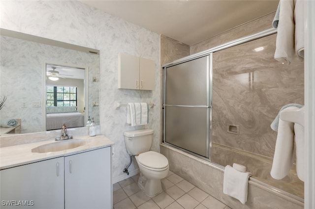 bathroom featuring vanity, wallpapered walls, bath / shower combo with glass door, tile patterned flooring, and toilet