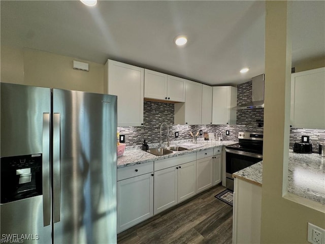 kitchen featuring a sink, wall chimney exhaust hood, white cabinetry, and stainless steel appliances