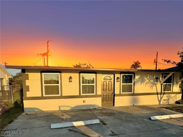 view of front of home with fence and stucco siding