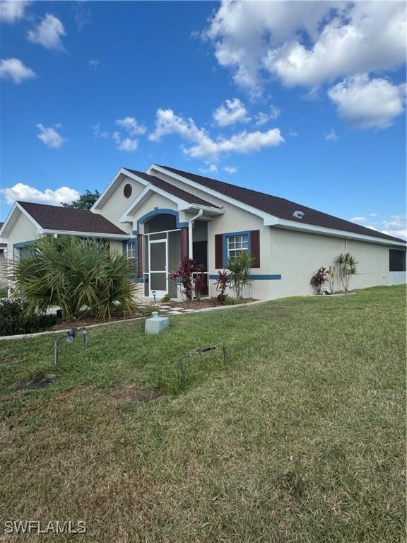 view of front of home featuring stucco siding and a front yard