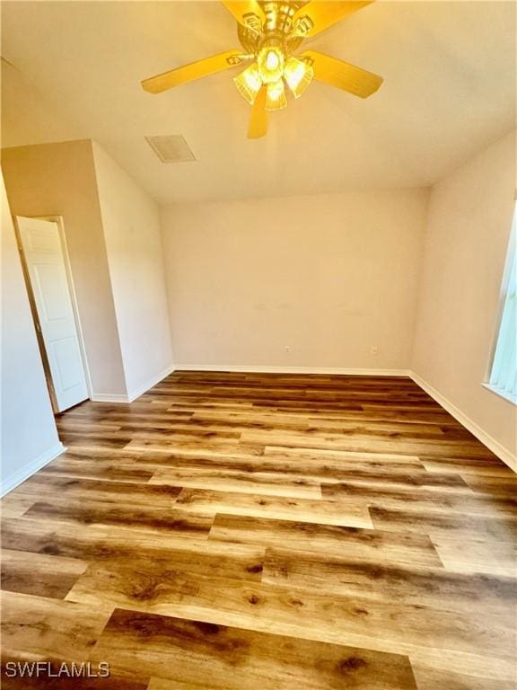 empty room with wood finished floors, baseboards, and ceiling fan