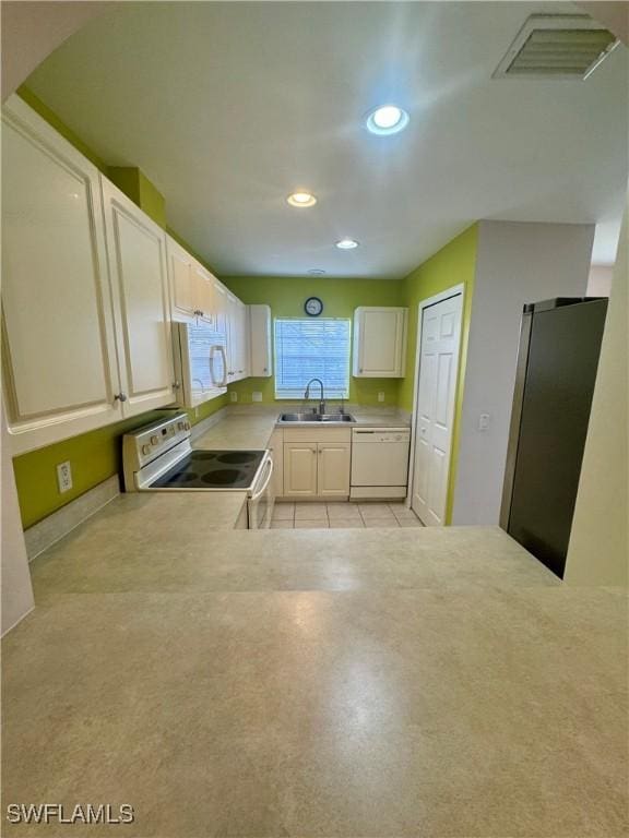 kitchen with visible vents, a sink, recessed lighting, white appliances, and light countertops