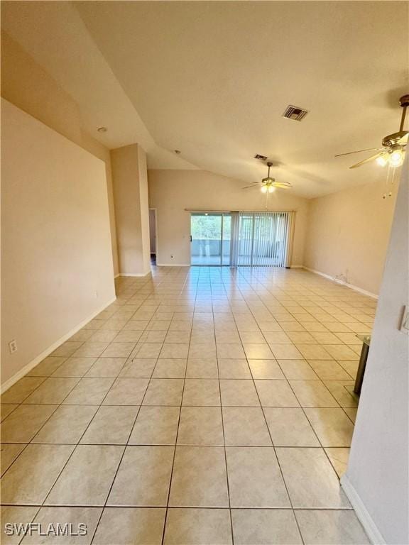 spare room featuring lofted ceiling, light tile patterned floors, visible vents, and ceiling fan