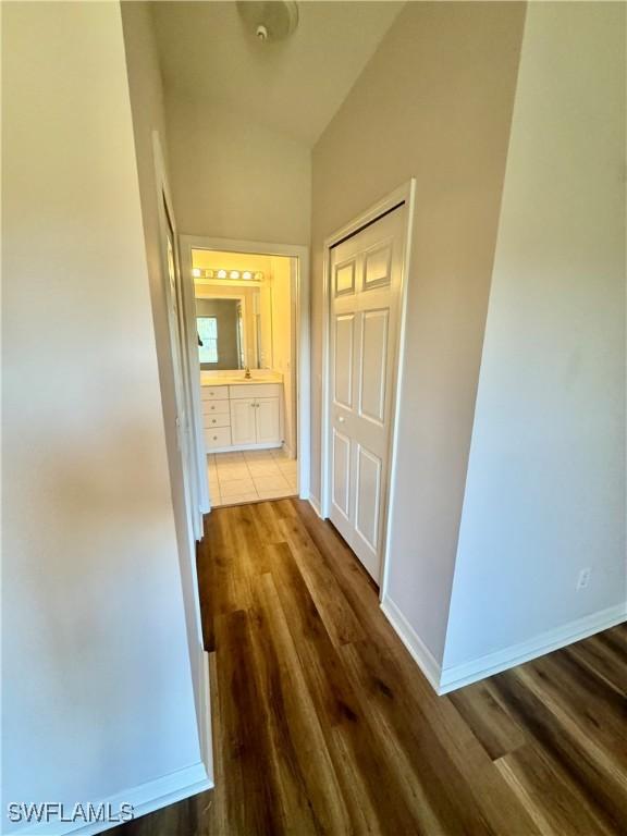 hallway with wood finished floors and baseboards