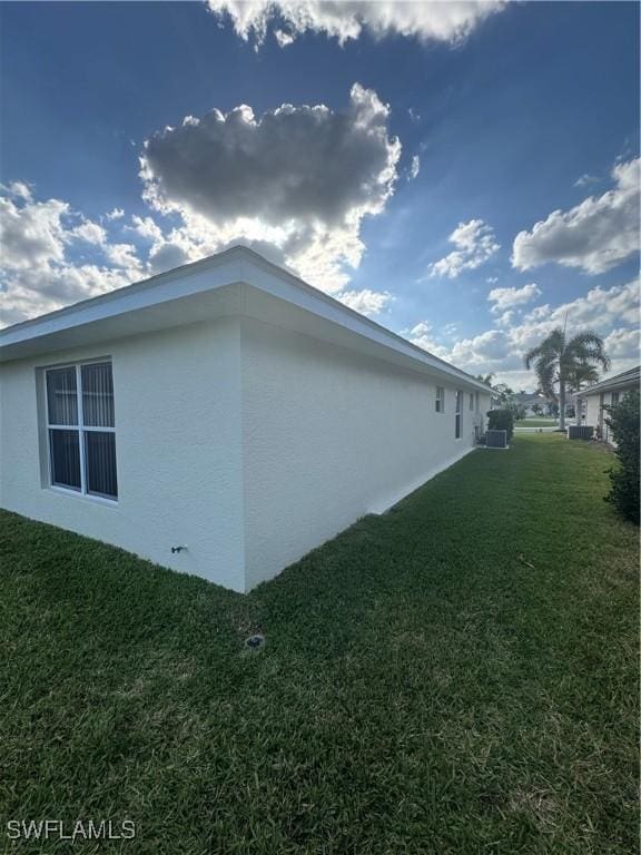 view of property exterior with stucco siding and a yard