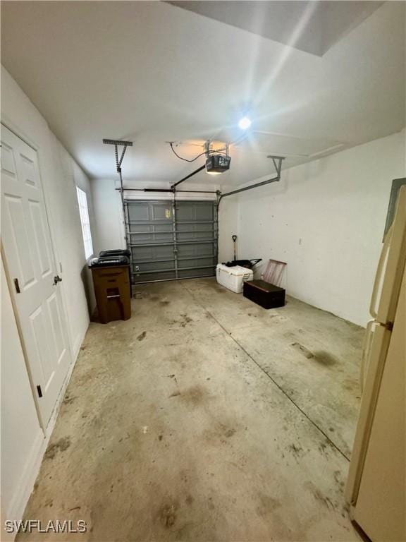 garage with a garage door opener and freestanding refrigerator