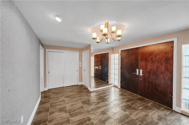 entrance foyer with baseboards and an inviting chandelier