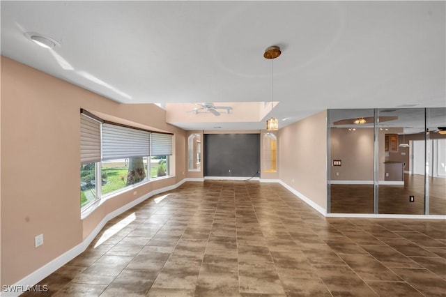 interior space featuring baseboards and ceiling fan