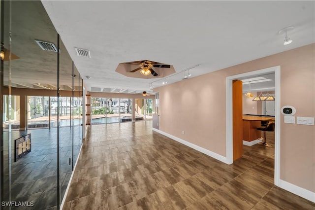 unfurnished room with a healthy amount of sunlight, visible vents, and baseboards