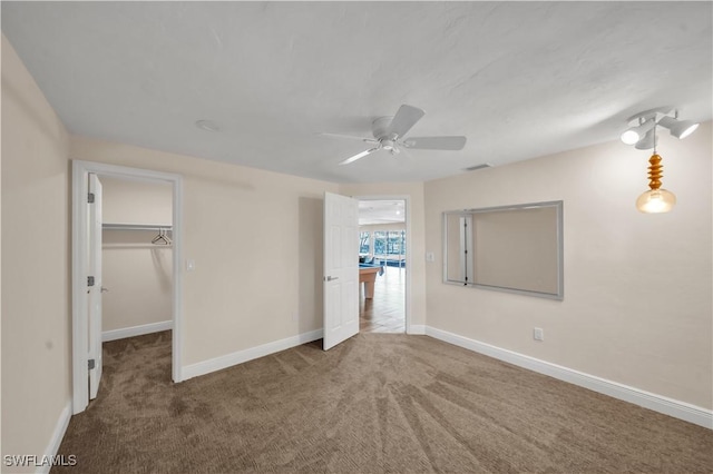 unfurnished bedroom featuring visible vents, carpet floors, baseboards, and a spacious closet