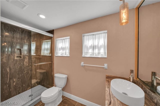 bathroom with a sink, toilet, a shower stall, and tile patterned flooring