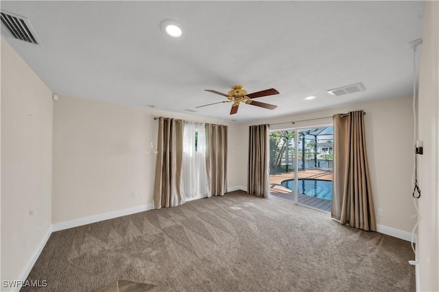 empty room featuring baseboards, visible vents, carpet floors, and ceiling fan