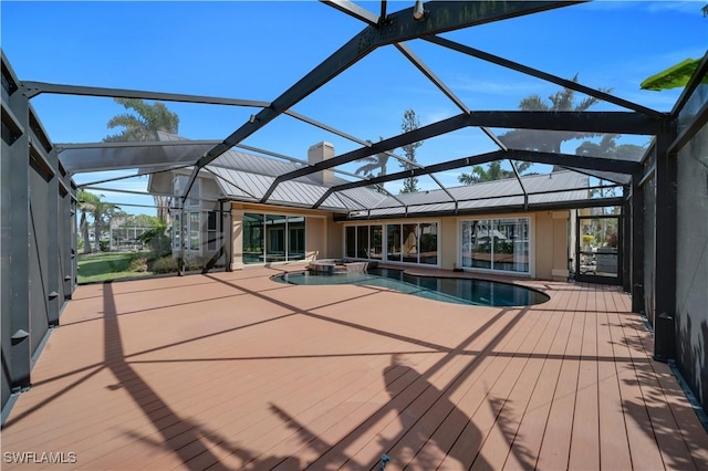 view of pool featuring glass enclosure and a pool with connected hot tub