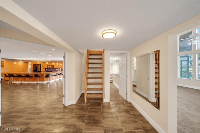 corridor featuring stairway and baseboards