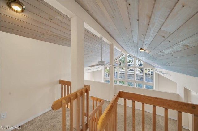 hall with baseboards, lofted ceiling, wood ceiling, carpet flooring, and an upstairs landing