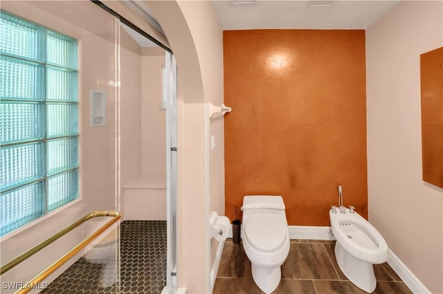 bathroom with a bidet, baseboards, a stall shower, tile patterned floors, and toilet