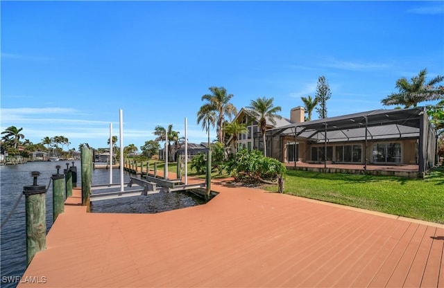 view of dock with glass enclosure, a water view, boat lift, and a yard