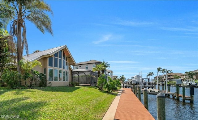 dock area featuring a water view, a lawn, a residential view, boat lift, and a lanai