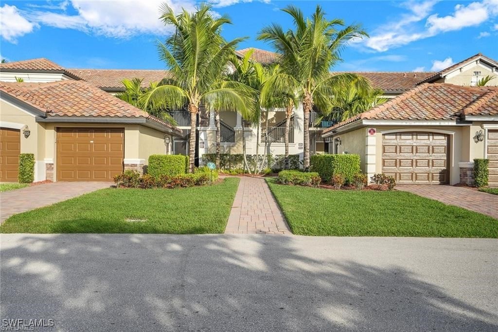 view of front facade featuring stucco siding, decorative driveway, a garage, and a tile roof