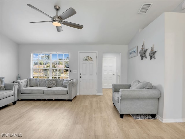 living area featuring light wood-style flooring, a ceiling fan, visible vents, and baseboards