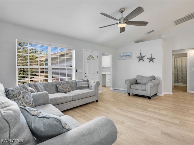 living area featuring visible vents, light wood-style floors, a ceiling fan, and vaulted ceiling