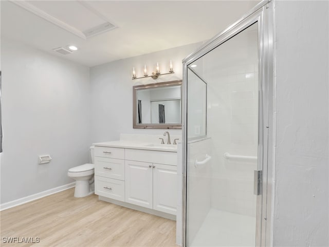 bathroom featuring vanity, toilet, wood finished floors, and a stall shower