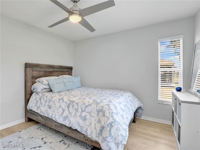 bedroom with light wood-style flooring, baseboards, and ceiling fan