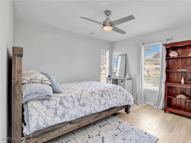 bedroom featuring baseboards, wood finished floors, and a ceiling fan