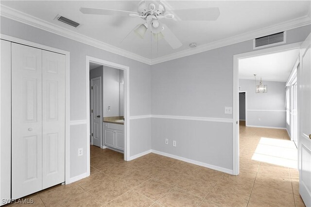 821 Casino Ave, Lehigh Acres, FL 33971 - unfurnished bedroom with a closet, light tile patterned flooring, ornamental molding, ceiling fan, and baseboards