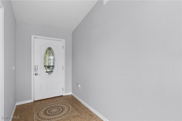 821 Casino Ave, Lehigh Acres, FL 33971 - tiled foyer entrance featuring lofted ceiling and baseboards