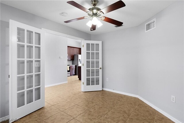 821 Casino Ave, Lehigh Acres, FL 33971 - unfurnished room featuring french doors, a smoke detector, light tile patterned flooring, a ceiling fan, and baseboards