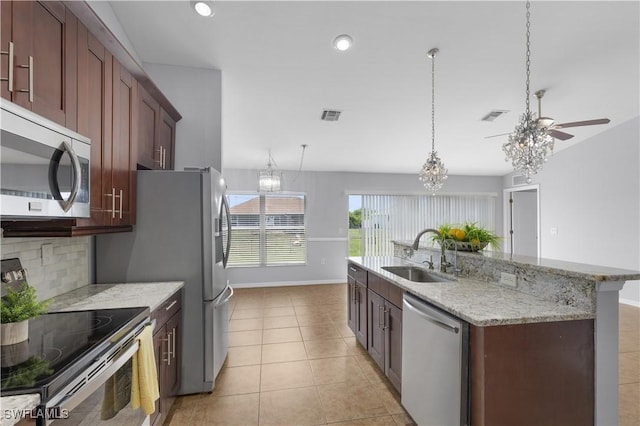 821 Casino Ave, Lehigh Acres, FL 33971 - kitchen featuring a sink, stainless steel appliances, a center island with sink, light tile patterned flooring, and tasteful backsplash