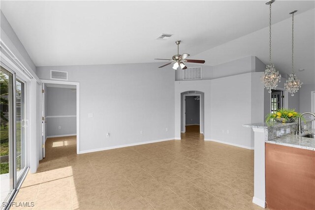 821 Casino Ave, Lehigh Acres, FL 33971 - unfurnished living room featuring lofted ceiling, a sink, a ceiling fan, arched walkways, and a chandelier