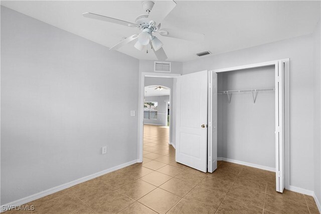 821 Casino Ave, Lehigh Acres, FL 33971 - unfurnished bedroom with arched walkways, tile patterned floors, baseboards, and a closet