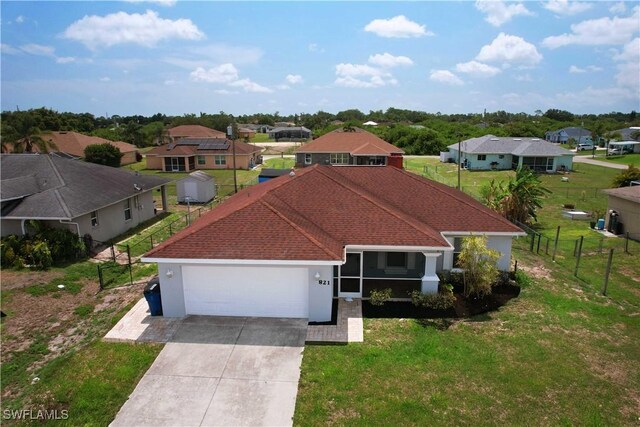 821 Casino Ave, Lehigh Acres, FL 33971 - view of front of home featuring a residential view, an attached garage, driveway, and stucco siding