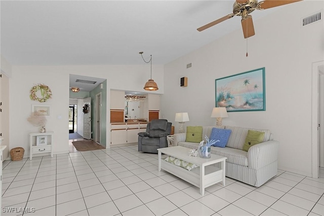 living room featuring light tile patterned floors, visible vents, a ceiling fan, and vaulted ceiling